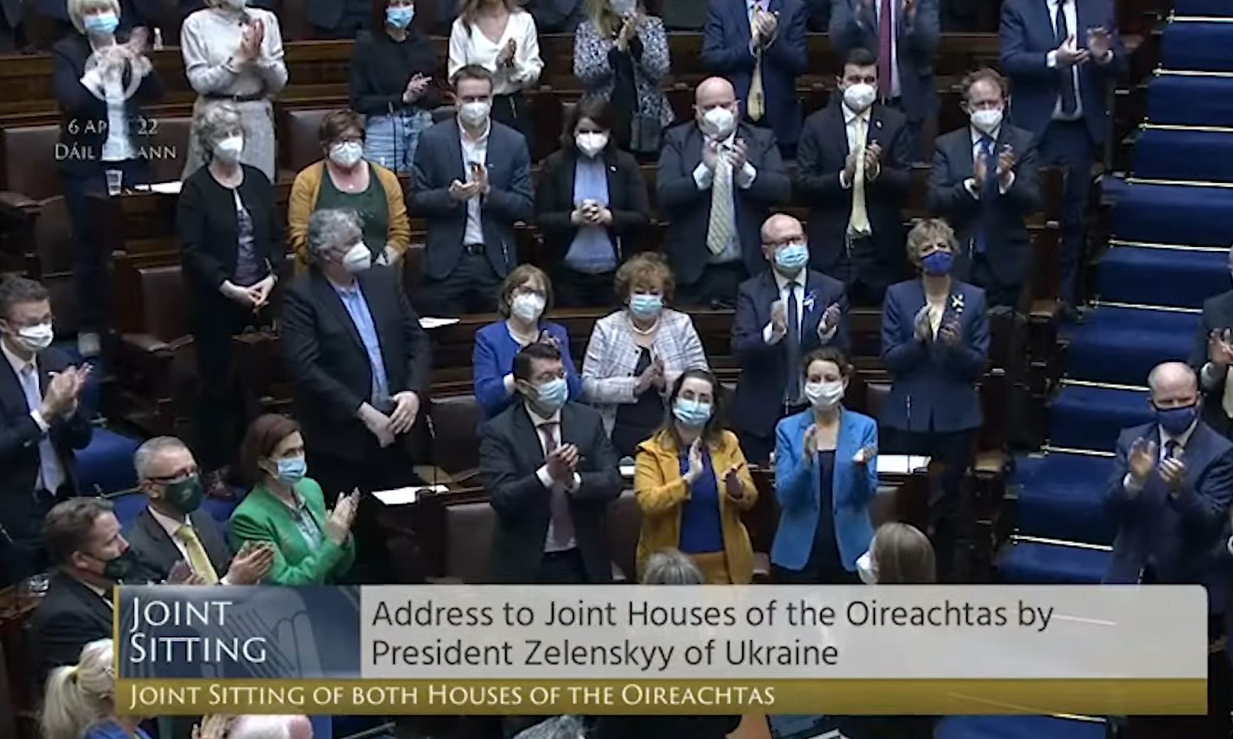 TDs stand and applaud in the Dáil chamber.