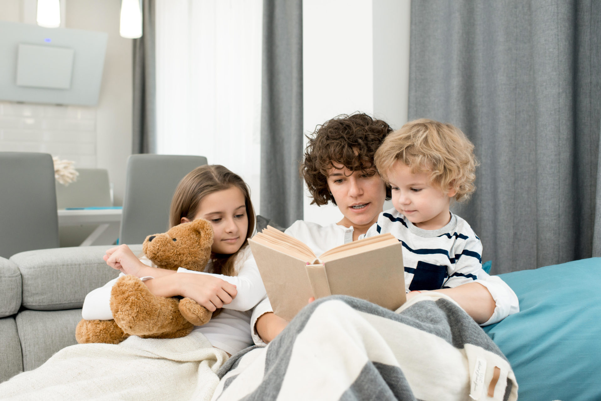 A woman reads a book to children
